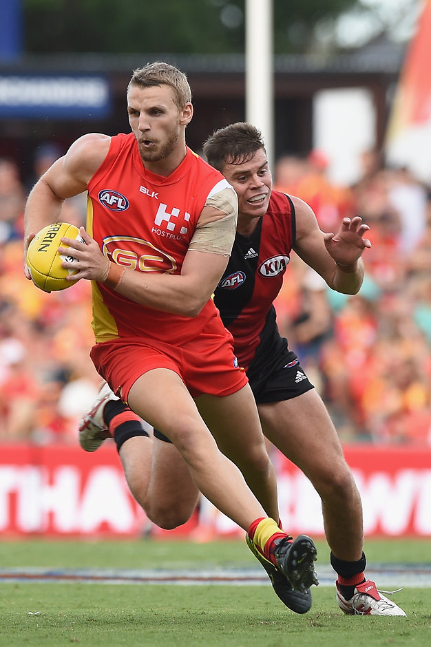 AFL 2016 Rd 01 - Gold Coast v Essendon GOLD COAST, AUSTRALIA - MARCH 26: Trent McKenzie of the Suns runs with the ball during the 2016 AFL Round 01 match between the Gold Coast Suns and the Essendon Bombers at Metricon Stadium, Gold Coast on March 26, 2016. (Photo by Matt Roberts/AFL Media)